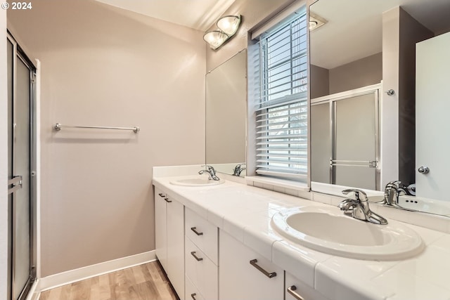 bathroom with hardwood / wood-style flooring, vanity, and a shower with shower door