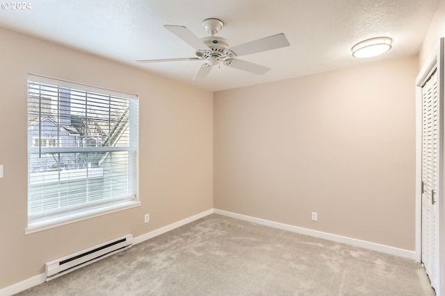 unfurnished room featuring a textured ceiling, ceiling fan, light carpet, and a baseboard radiator