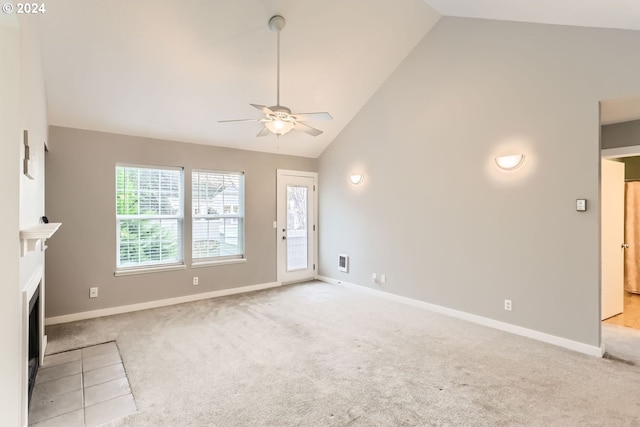 unfurnished living room with light carpet, high vaulted ceiling, an AC wall unit, and a wealth of natural light