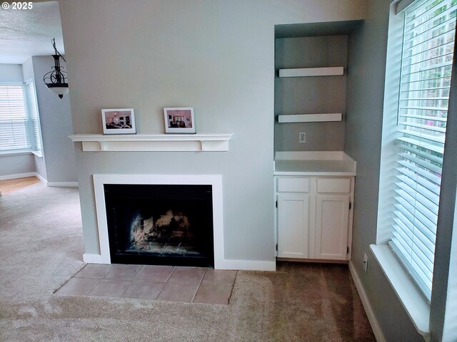 8550 SW Curry Dr Unit A, Wilsonville, OR 97070 - unfurnished living room with carpet floors, baseboards, a fireplace with flush hearth, and built in features