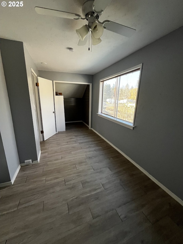 spare room featuring a ceiling fan, baseboards, and wood finished floors