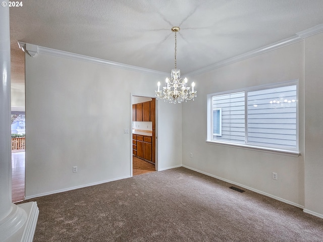 carpeted spare room featuring ornamental molding and a notable chandelier