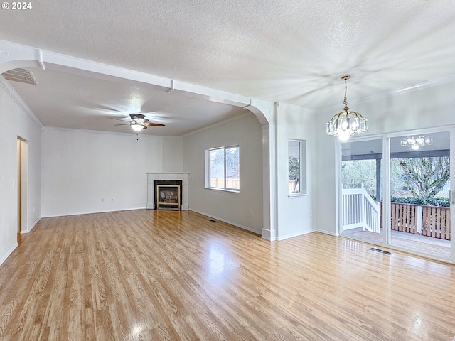 unfurnished living room featuring a fireplace, a textured ceiling, light hardwood / wood-style flooring, and crown molding