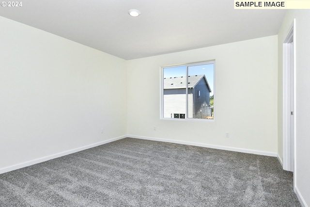 unfurnished room featuring dark carpet