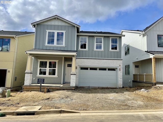 view of front of house with an attached garage, driveway, a porch, and board and batten siding