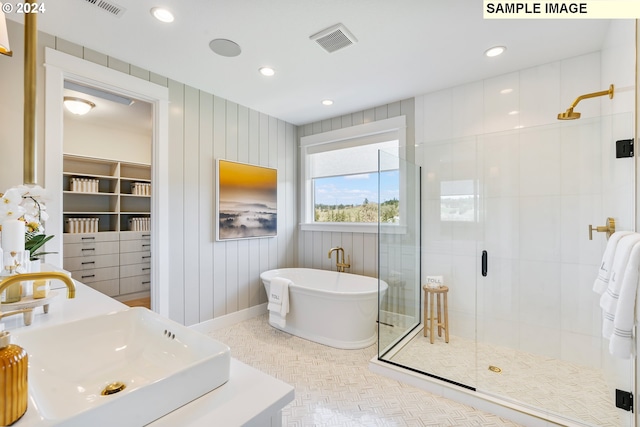 bathroom with visible vents, a soaking tub, a shower stall, a sink, and recessed lighting