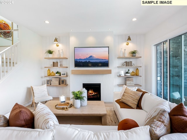 living room featuring stairway, recessed lighting, and a lit fireplace