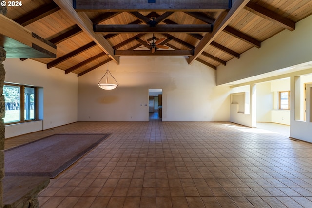 unfurnished room with beam ceiling, high vaulted ceiling, plenty of natural light, and wooden ceiling