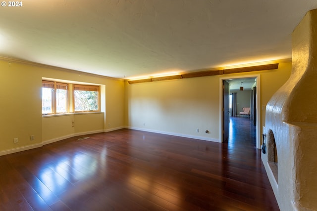 spare room featuring dark hardwood / wood-style floors and ornamental molding