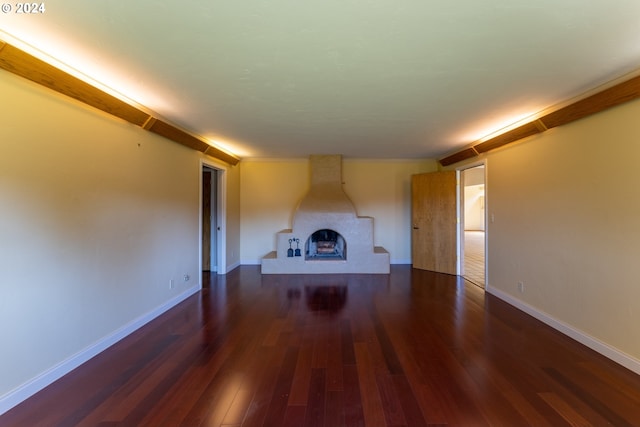 unfurnished living room with dark hardwood / wood-style floors and a large fireplace