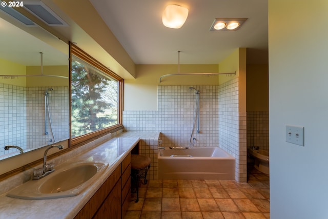 bathroom featuring tile patterned floors, a bidet, vanity, tile walls, and tiled shower / bath