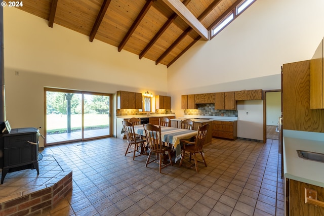 dining space featuring beamed ceiling, wood ceiling, high vaulted ceiling, and a wood stove