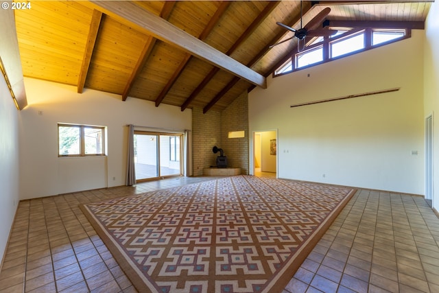 unfurnished living room featuring beam ceiling, high vaulted ceiling, wooden ceiling, tile patterned flooring, and a wood stove