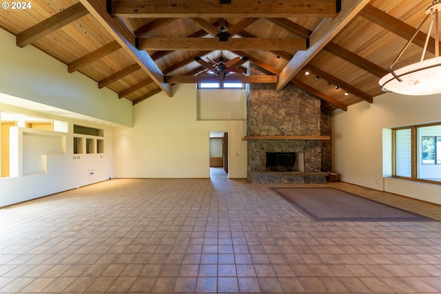 unfurnished living room featuring wooden ceiling, high vaulted ceiling, a stone fireplace, light tile patterned floors, and beam ceiling