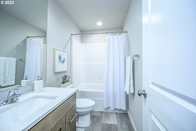 full bathroom featuring toilet, wood-type flooring, shower / bathtub combination with curtain, and vanity