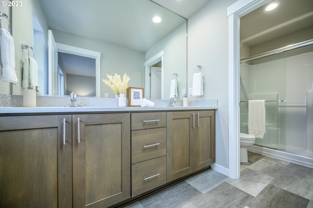 bathroom with vanity, toilet, and a shower with shower door