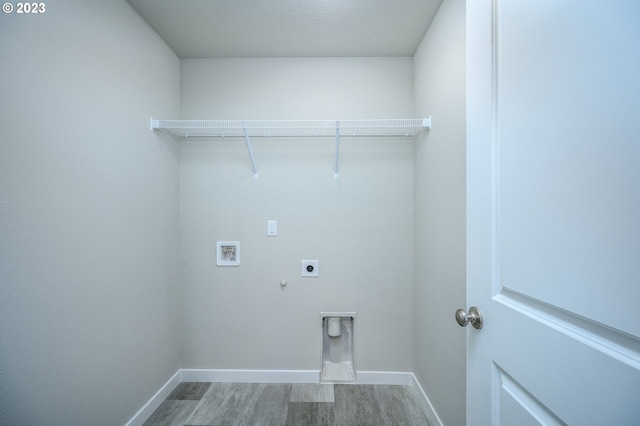 washroom featuring gas dryer hookup, hookup for a washing machine, wood-type flooring, and hookup for an electric dryer