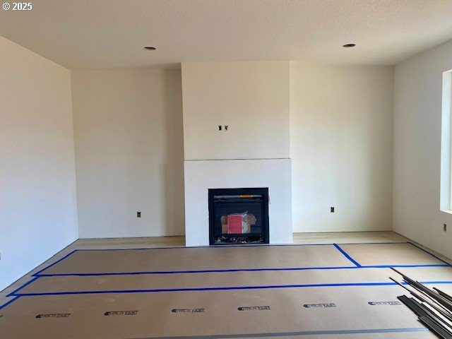 unfurnished living room with a fireplace and a textured ceiling