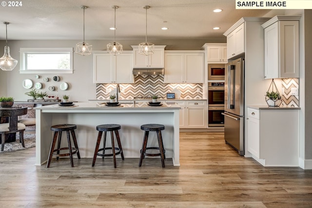 kitchen featuring pendant lighting, white cabinetry, an island with sink, and appliances with stainless steel finishes