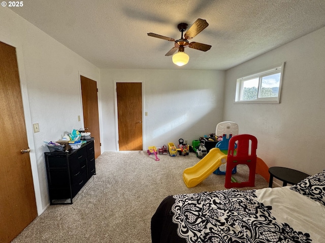 carpeted bedroom with ceiling fan and a textured ceiling