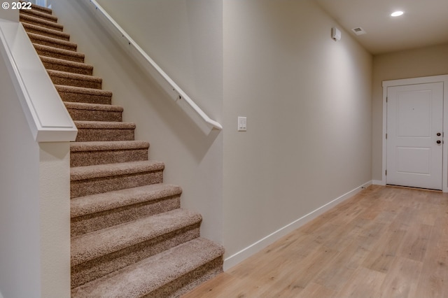 stairs featuring hardwood / wood-style floors