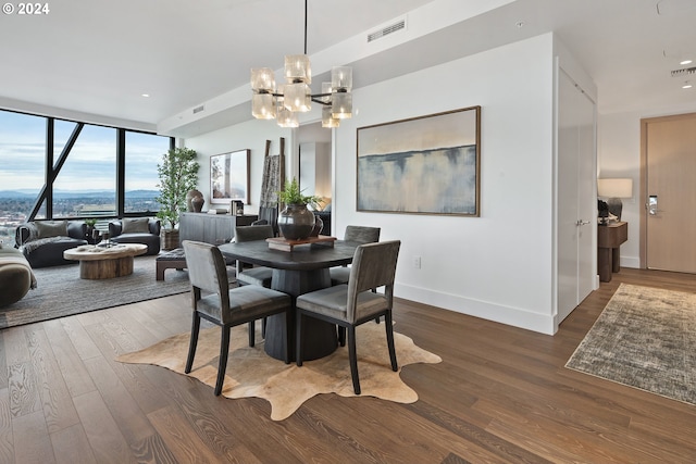 dining area with dark wood-type flooring and a notable chandelier