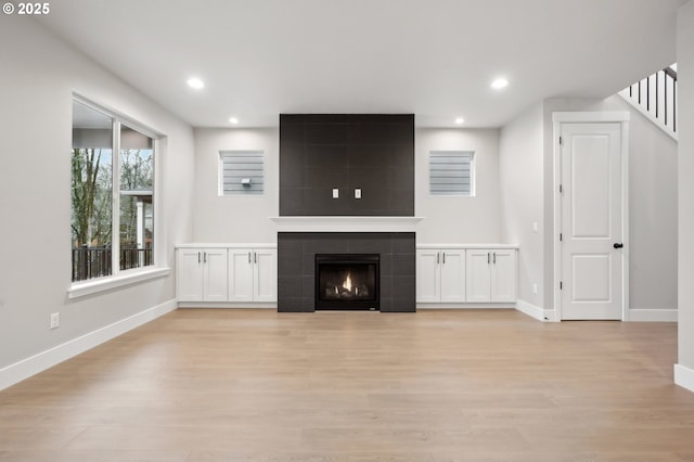 kitchen featuring dark brown cabinetry, wood-type flooring, decorative light fixtures, a kitchen bar, and a center island with sink