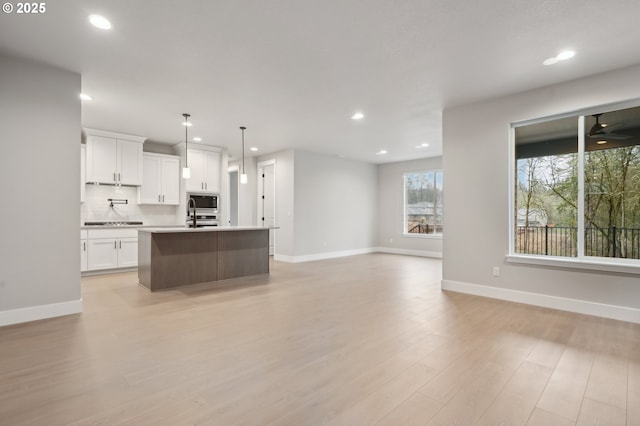 unfurnished living room featuring light hardwood / wood-style floors and a tiled fireplace