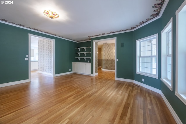 interior space featuring light wood-type flooring and ornamental molding