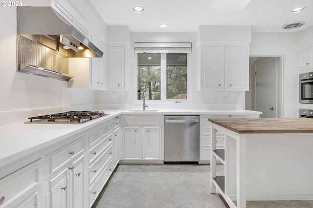 kitchen with stainless steel appliances, white cabinets, wooden counters, and sink