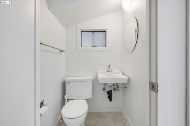 bathroom with lofted ceiling, sink, and toilet