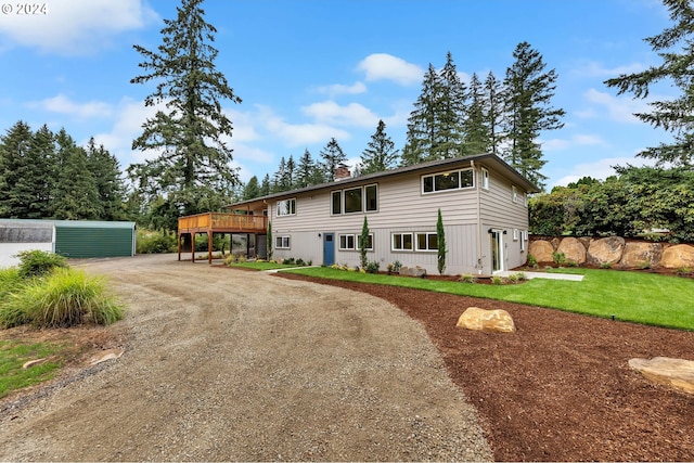 view of front of property with a front yard, an outbuilding, and a wooden deck