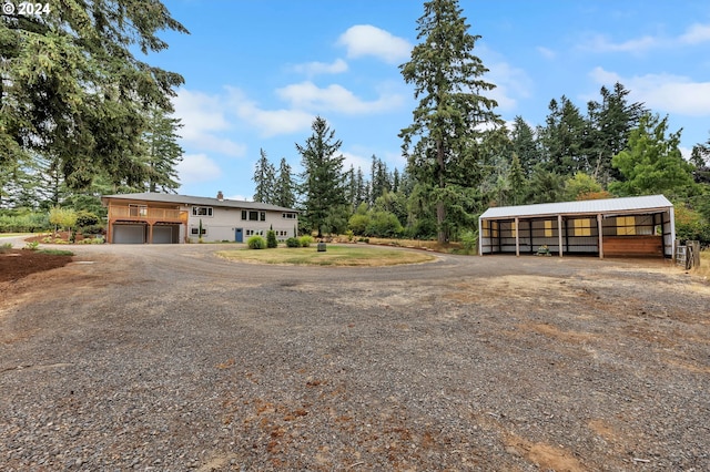 view of front of home with a garage and an outbuilding