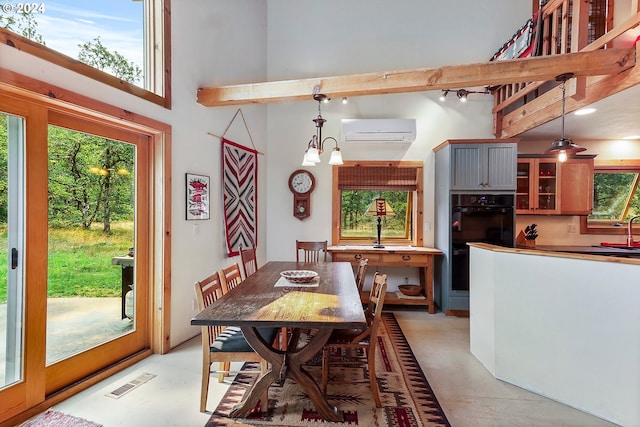 dining room with sink, a towering ceiling, beam ceiling, a wall unit AC, and a chandelier