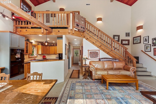 interior space featuring beamed ceiling, sink, and high vaulted ceiling