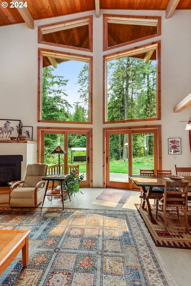 sunroom with vaulted ceiling with beams, plenty of natural light, and wooden ceiling