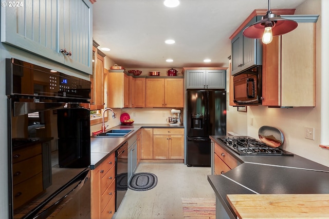 kitchen featuring black appliances, decorative light fixtures, and sink