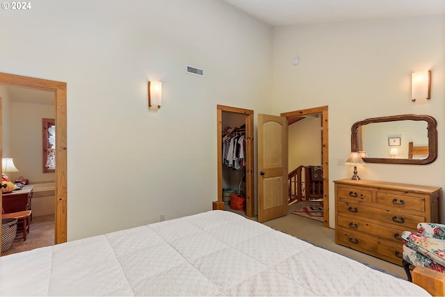 carpeted bedroom with a towering ceiling, ensuite bath, a spacious closet, and a closet