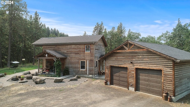 cabin featuring a garage and an outdoor structure