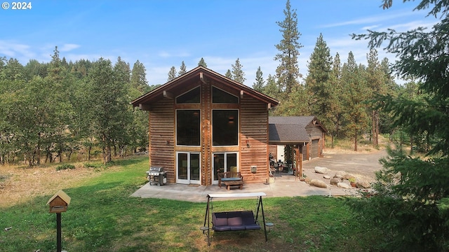 back of property featuring an outdoor structure, a patio area, and a yard