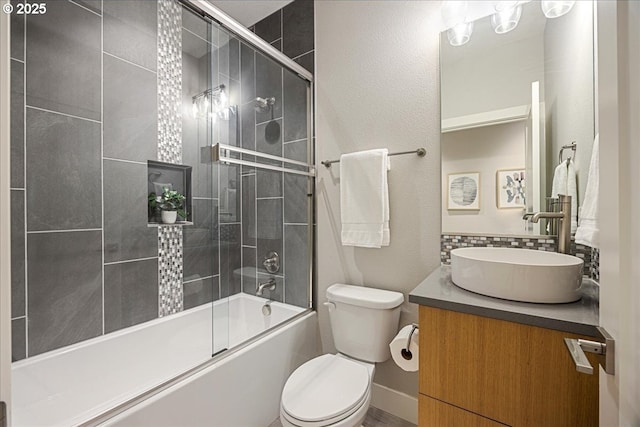 full bathroom featuring vanity, shower / bath combination with glass door, and toilet