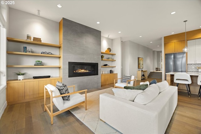 17808 Hillside Way, Lake Oswego, OR 97034 - living area with light wood-type flooring, a tiled fireplace, recessed lighting, and built in shelves