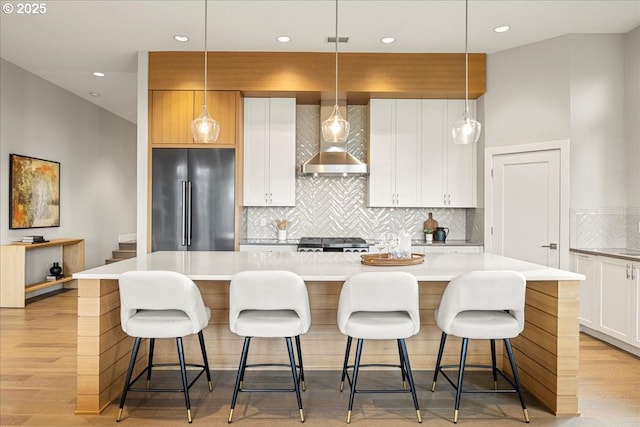 kitchen with black fridge, a large island, tasteful backsplash, and pendant lighting