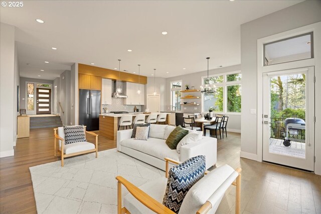 living area featuring recessed lighting, baseboards, and light wood-style flooring