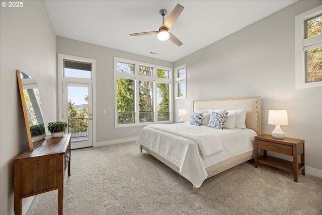 bedroom with multiple windows, access to exterior, light colored carpet, and ceiling fan