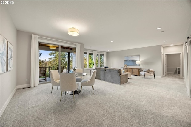 dining area with light colored carpet and a barn door