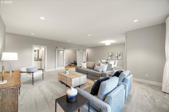 living room featuring a barn door and light colored carpet