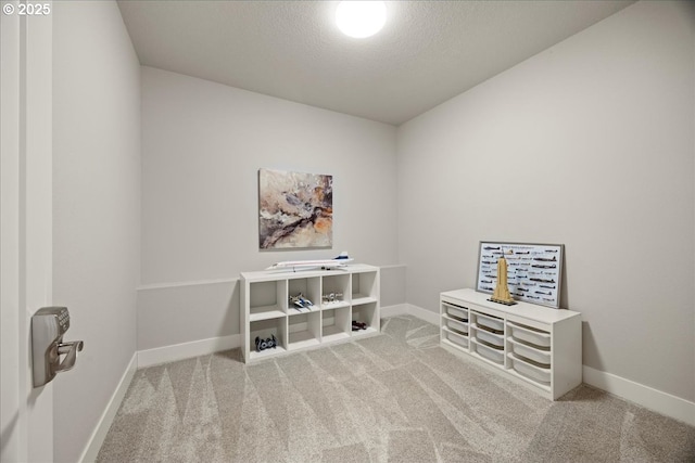 unfurnished room with baseboards, carpet, and a textured ceiling