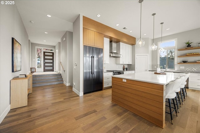 17808 Hillside Way, Lake Oswego, OR 97034 - kitchen with built in refrigerator, wall chimney range hood, open shelves, backsplash, and wood finished floors