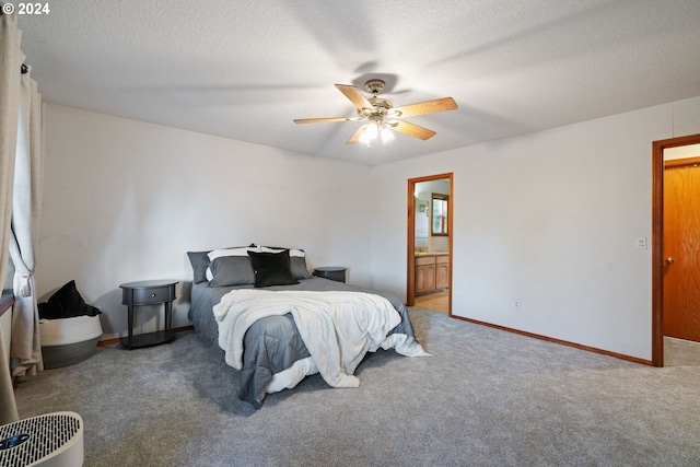 carpeted bedroom featuring a textured ceiling, ensuite bath, and ceiling fan